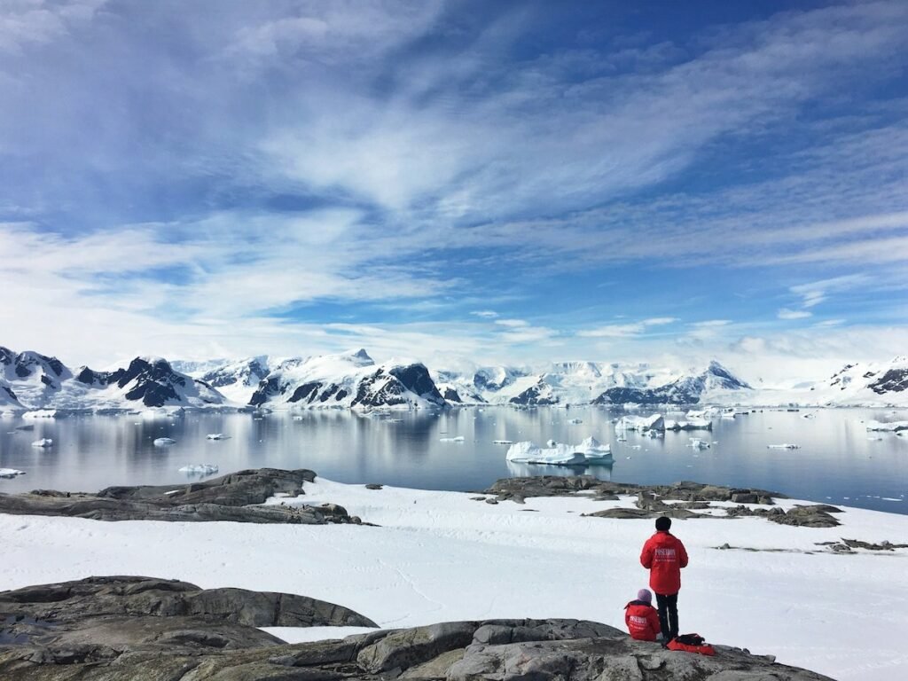 Two people standing on the snow of Antarctica