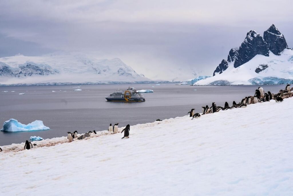 Luxury expedition cruise ship sailing near an Antarctic glacier